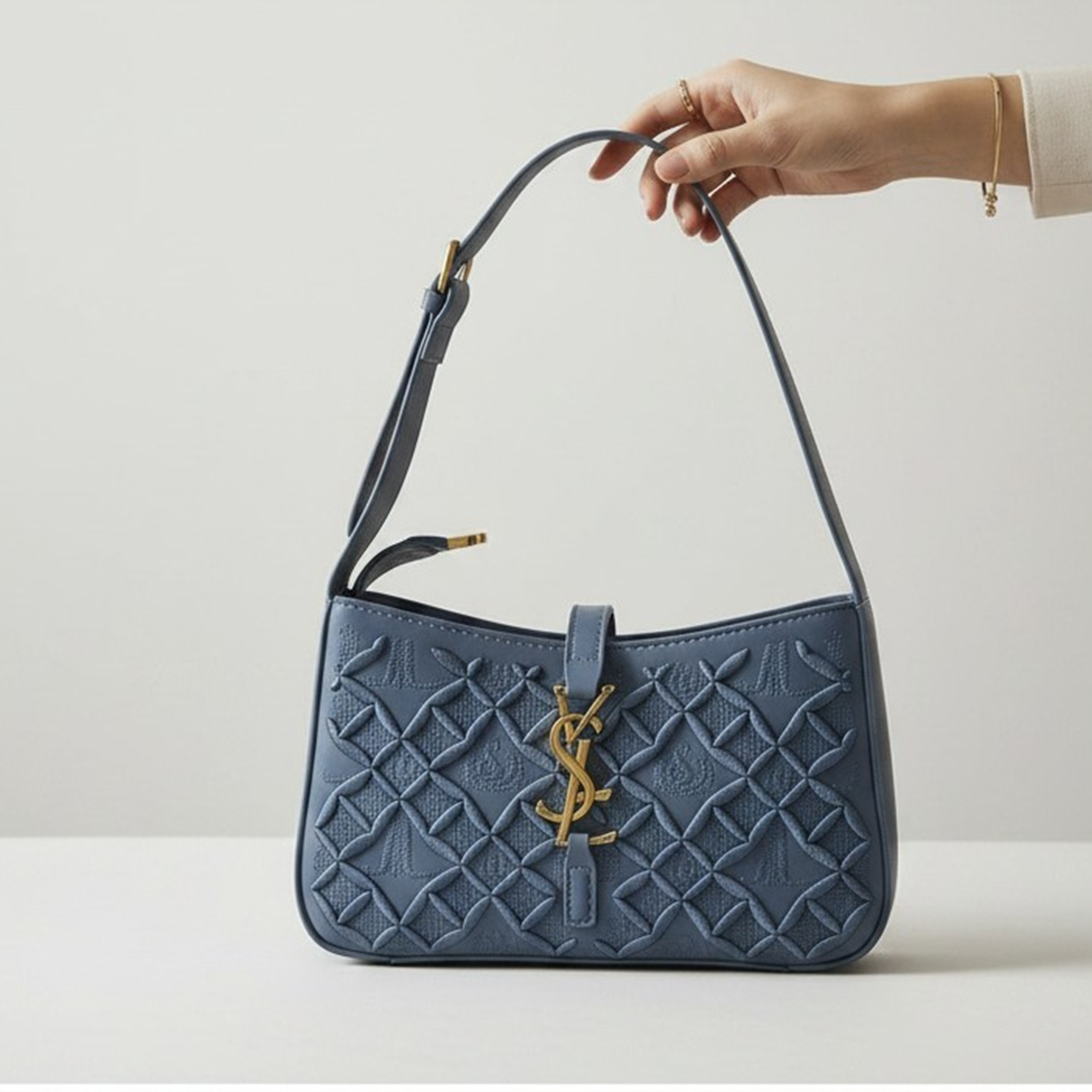 Saint Laurent Le 5 à 7 hobo bag slate blue quilted held up against white wall