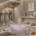 Coach Cassy hobo bag petal pink held up in luxury boutique showing braided chain strap