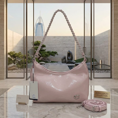 Coach Cassy hobo bag petal pink on marble table with Burj Al Arab view in background