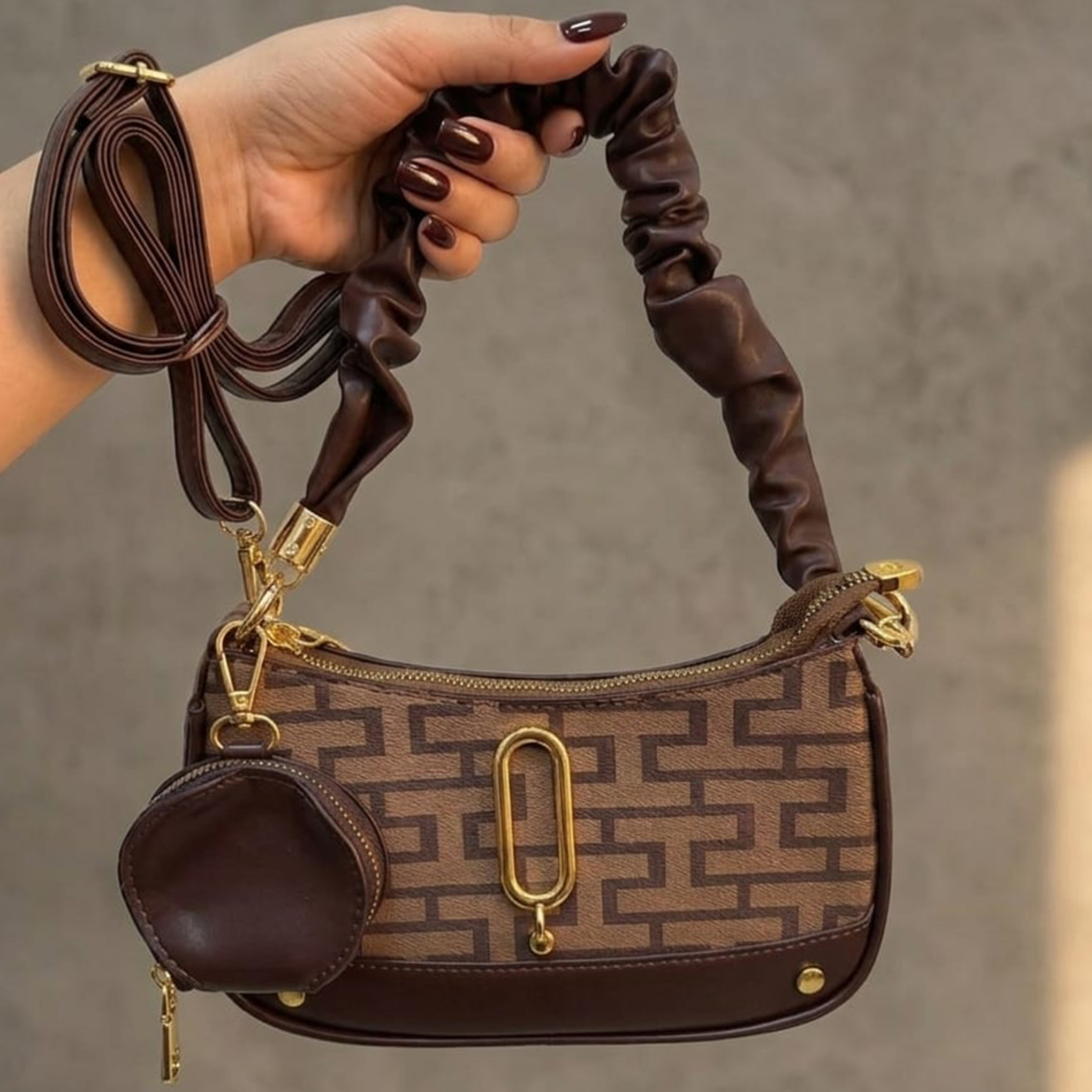 Marc Jacobs Snapshot hobo bag brown monogram held up outdoors