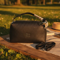 Miu Miu Madras leather bowling bag in dark brown on wooden bench in park at golden hour