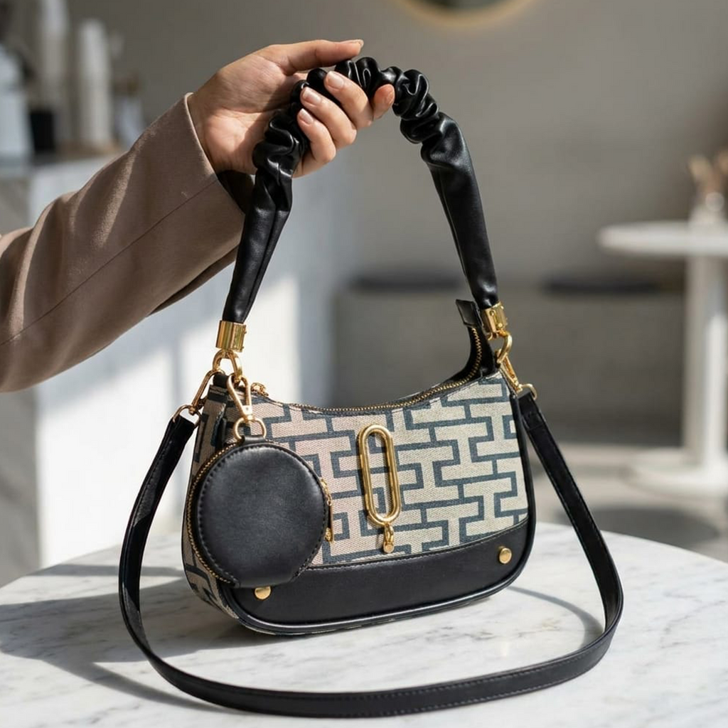 Marc Jacobs Snapshot hobo bag black monogram held up on marble table in modern interior
