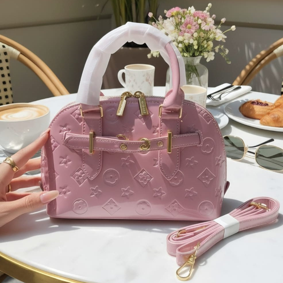 Louis Vuitton Speedy Bandoulière rose pink monogram empreinte on marble cafe table with latte and flowers