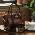 Longchamp Roseau bowling bag dark brown on cafe table with steaming latte and logo jacquard strap